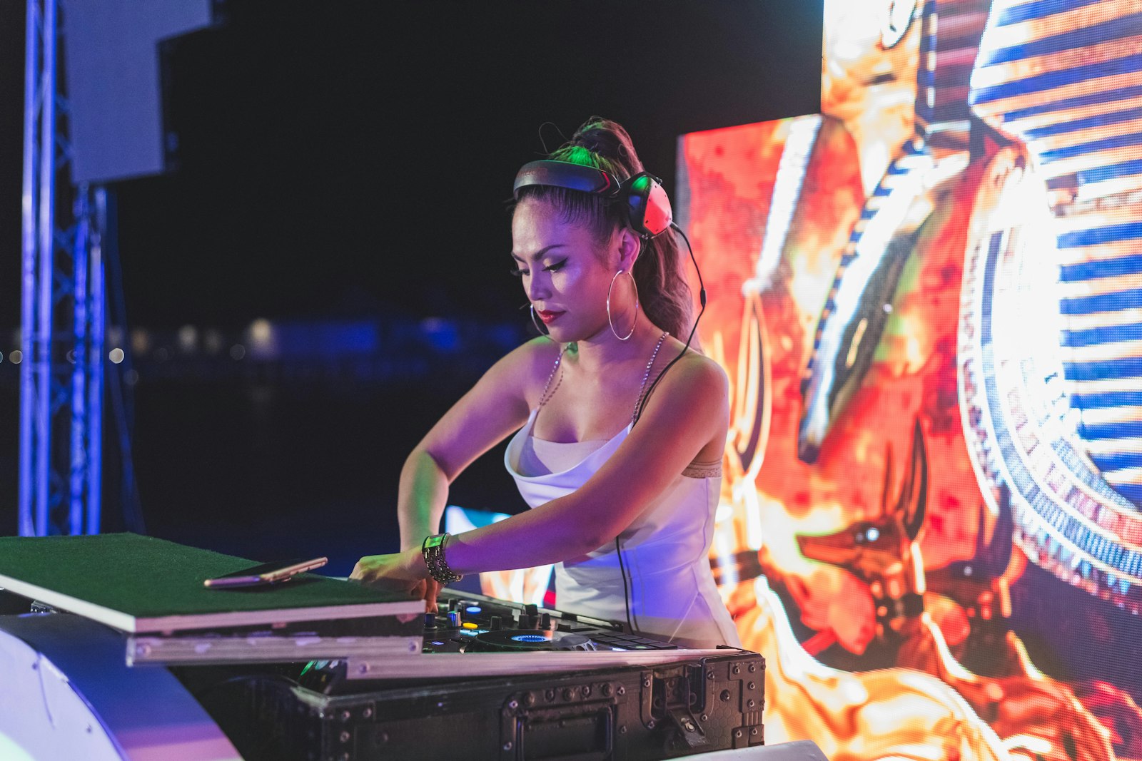 woman in green tank top wearing green headphones playing dj controller